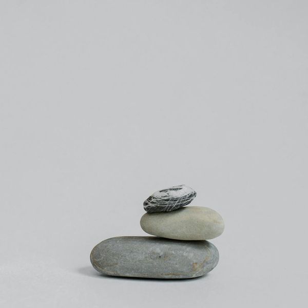 Conceptual image of balanced stones near a cold lake